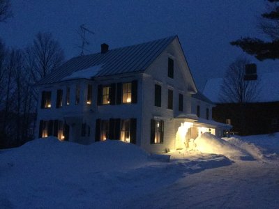 large white house in deep twilight surrounded by snow